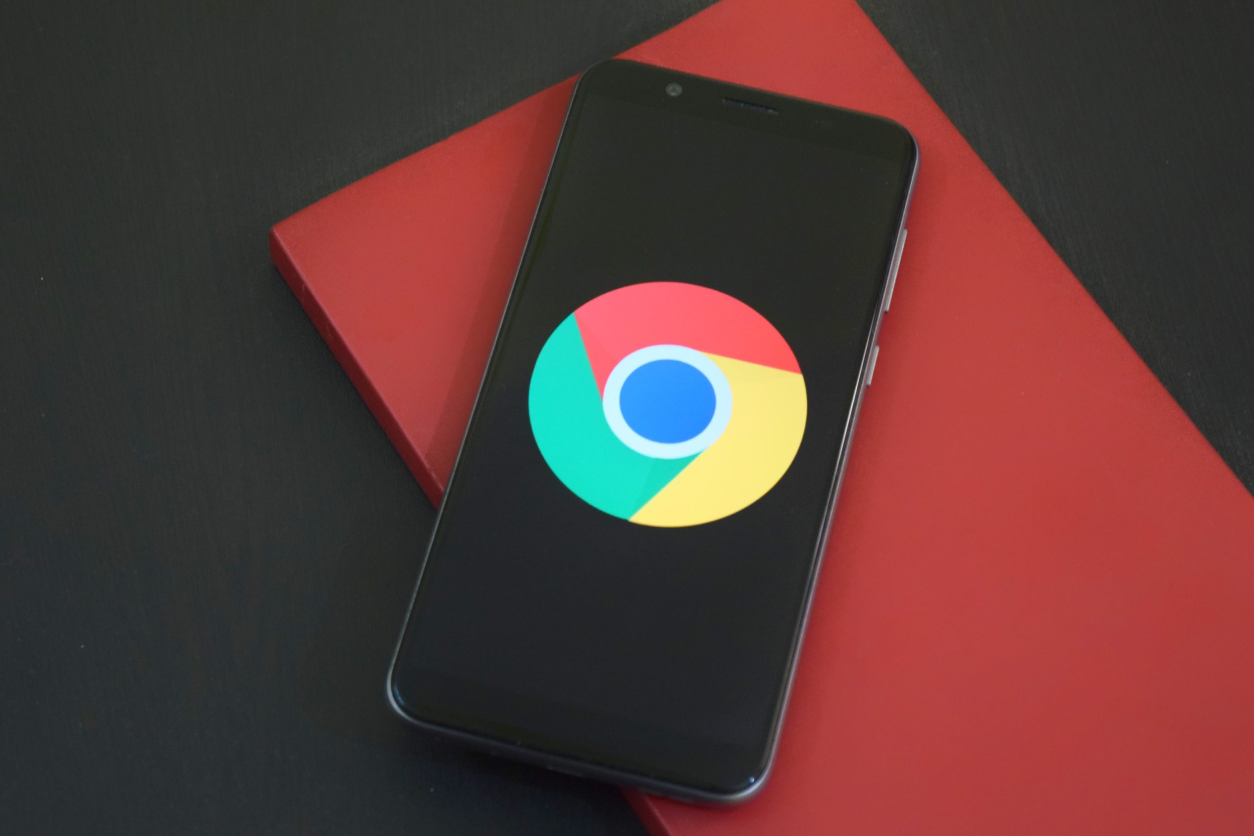 cell phone with google chrome logo on red and black table